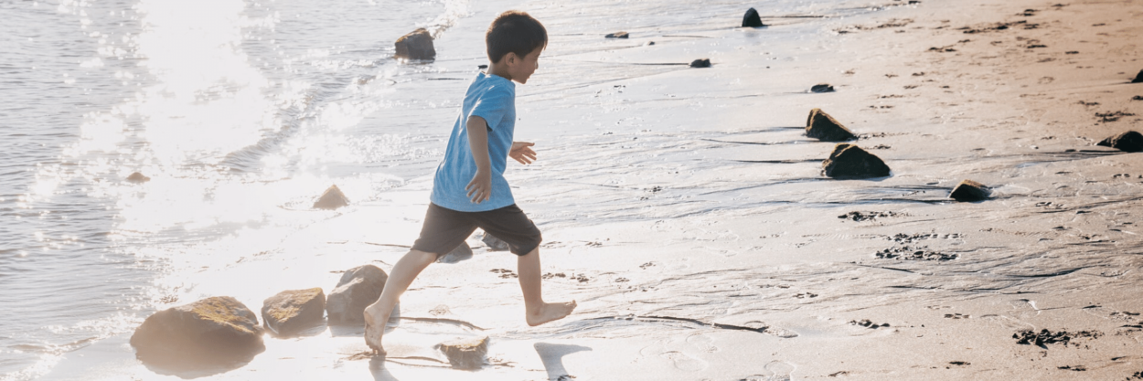 A small boy running on the beach