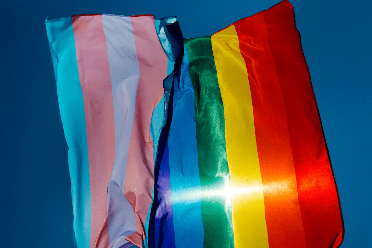 Gay and trans flags waving in the sun
